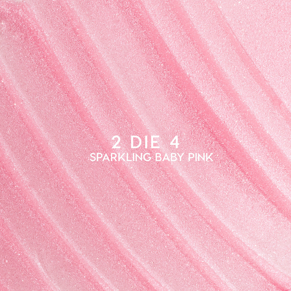 Heart to Get 2 Die 4 ultra glossy lip swatch showing sparkling baby pink shimmer in diagonal, textured streaks against a smooth pastel background, highlighting the high-shine, glittery finish for US makeup lovers.