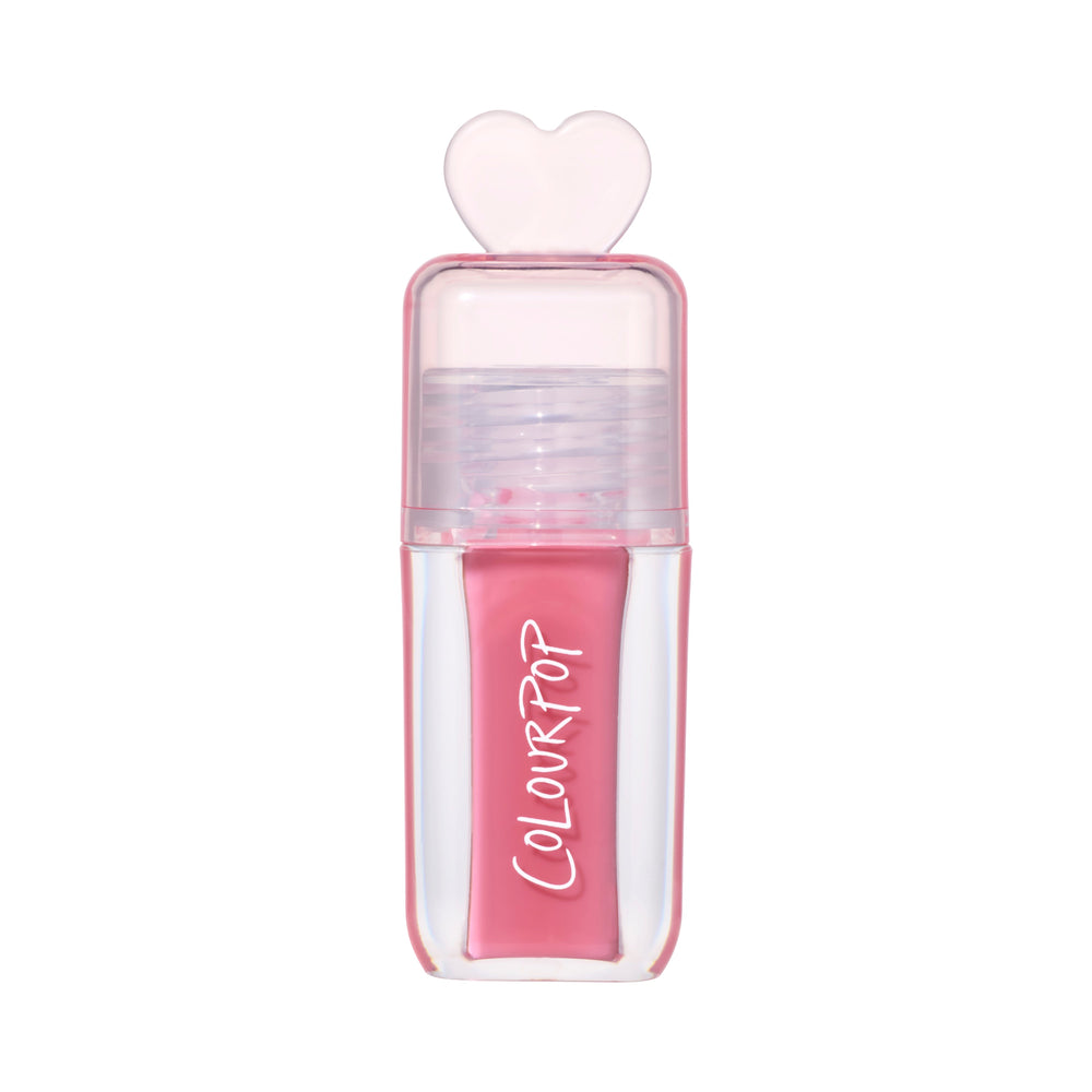 ColourPop Still That Girl ultra glossy lip in pink, standing upright with a clear rectangular tube, heart-shaped cap, and Heart to Get inspired packaging on a clean white background for a modern makeup product shot.