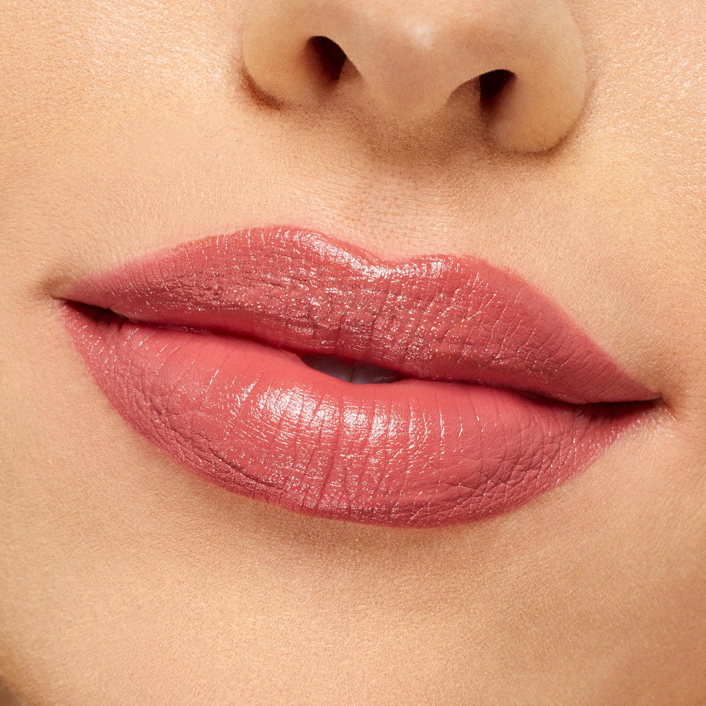 Lips wearing ColourPop Lippie Stix It’s Giving, a rosy pink nude shade with a creamy, slightly glossy finish, evenly applied in a tight close-up against clean skin to showcase smooth pigment and hydration.