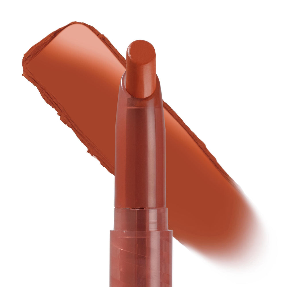 Ziggie Lippie Stix by ColourPop standing upright with tip exposed, a warm terracotta-brown swatch swept behind to show creamy matte payoff on a white background; ColourPop Lippie Stix product close-up.